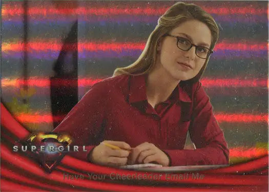 Woman with glasses in red top at desk, featuring Supergirl Season 1 Rainbow Foil Board