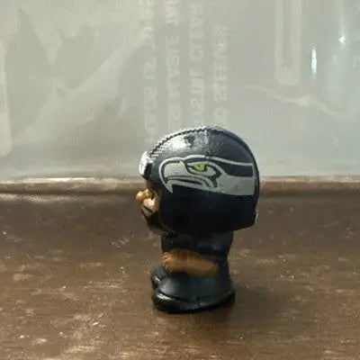 Dark blue toy football helmet with Seattle Seahawks logo and Russell Wilson figure