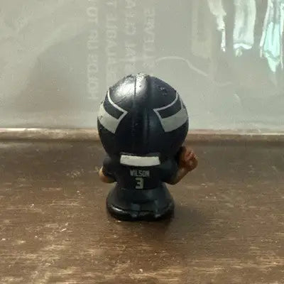 Dark blue Seattle Seahawks Russell Wilson NFL figurine with white helmet stripes and brown football