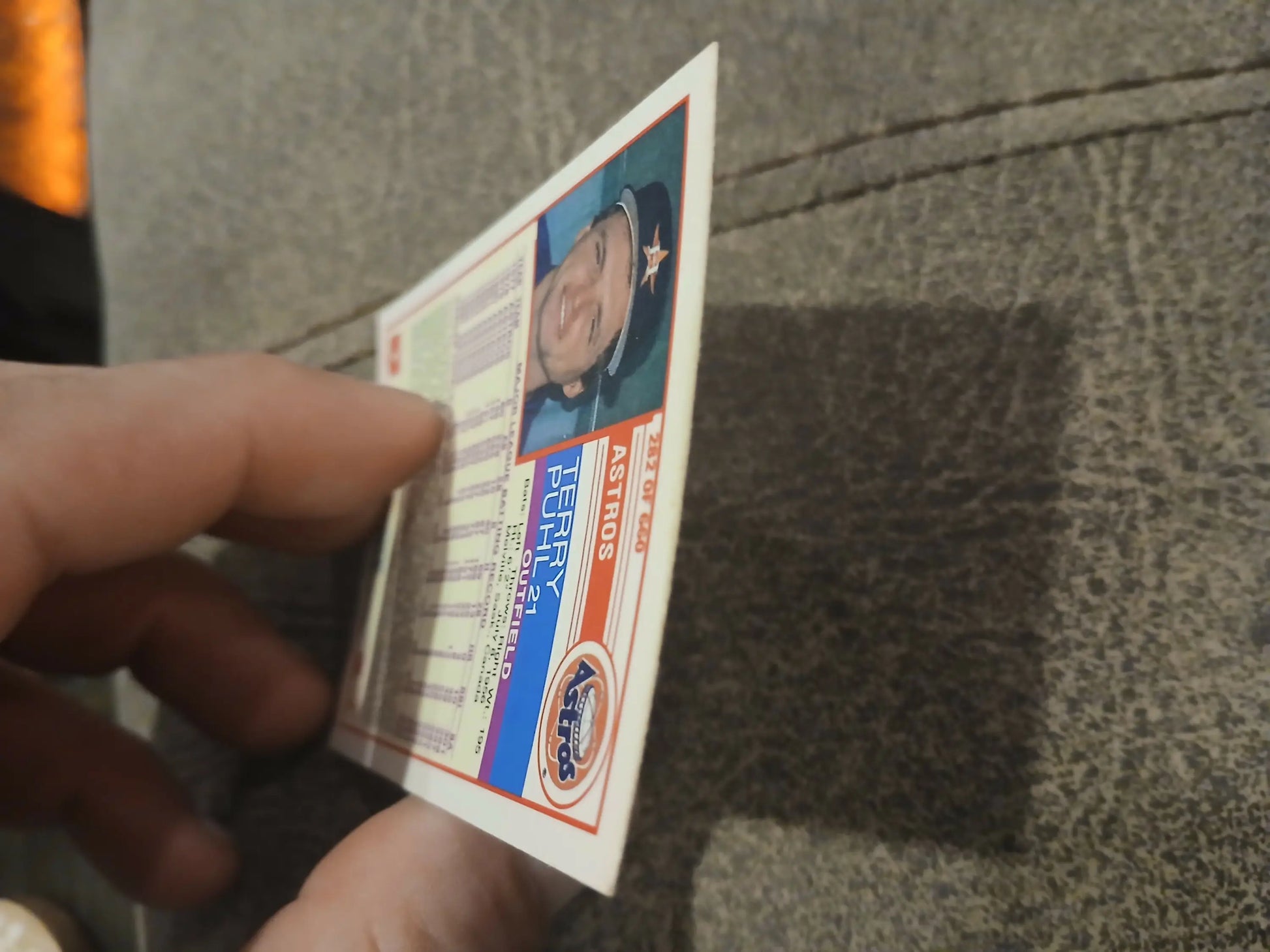 Driver’s license held at an angle next to Terry Puhl baseball card for trading cards