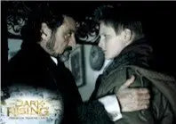 Black and white image of two men in suits embracing on The Seeker promo card, internet exclusive