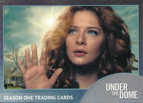 Woman with curly hair raising hand in Under the Dome P1 promo card background