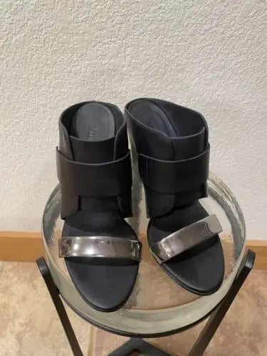 Black leather heeled sandals with silver accents from Vince, showcasing edgy sophistication in high heel wedge shoes