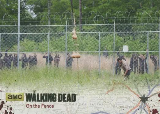 Chain-link fence with barbed wire and shadowy figures in Walking Dead Gold Foil Parallel
