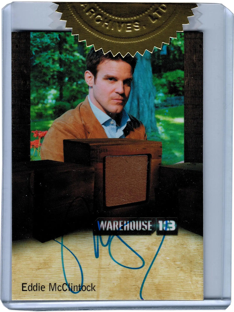 Autograph costume card featuring Eddie McClintock in a brown jacket against green background